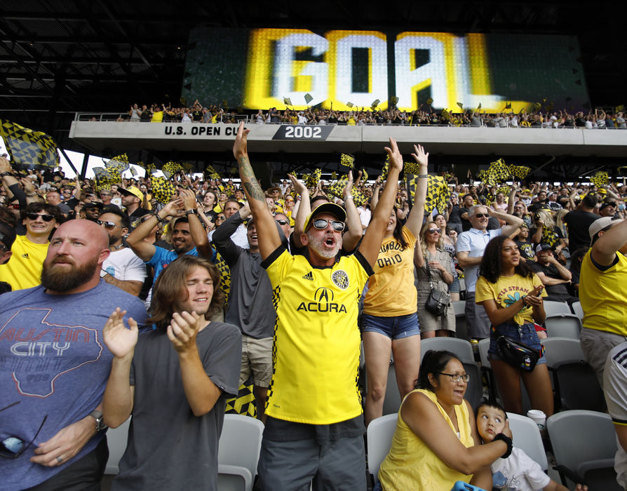 Sports Feature - 3rd place - July -  Columbus Crew fan Christopher Klopfer (center) celebrates after the Crew's second goal against New England Revolution in their first MLS game at Lower.com Field in Columbus. (Kyle Robertson / The Columbus Dispatch)  