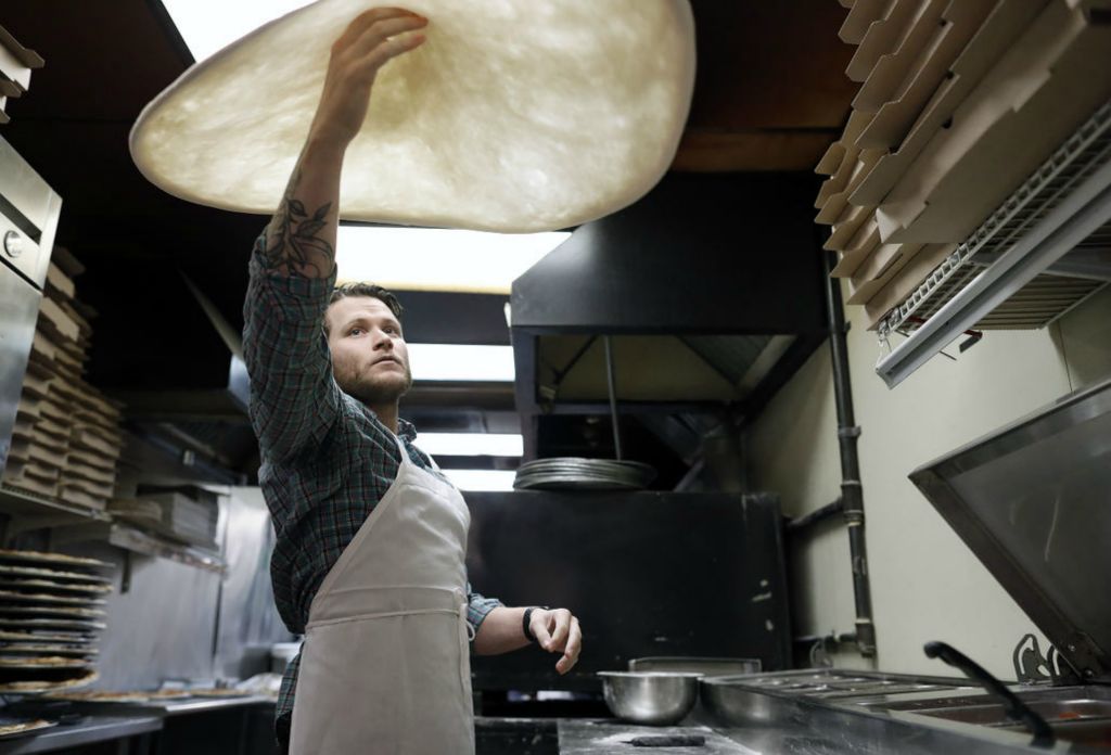 General News - 3rd place - October -  After 30 years on North High Street, Cafe Napolitana is moving to Gay Street and changed the name to Aracri Pizzeria on Gay Street.  Co-owner Dominic Aracri tosses pizza dough for a pizza in Cafe Napolitana on October 25.  (Kyle Robertson / The Columbus Dispatch) 