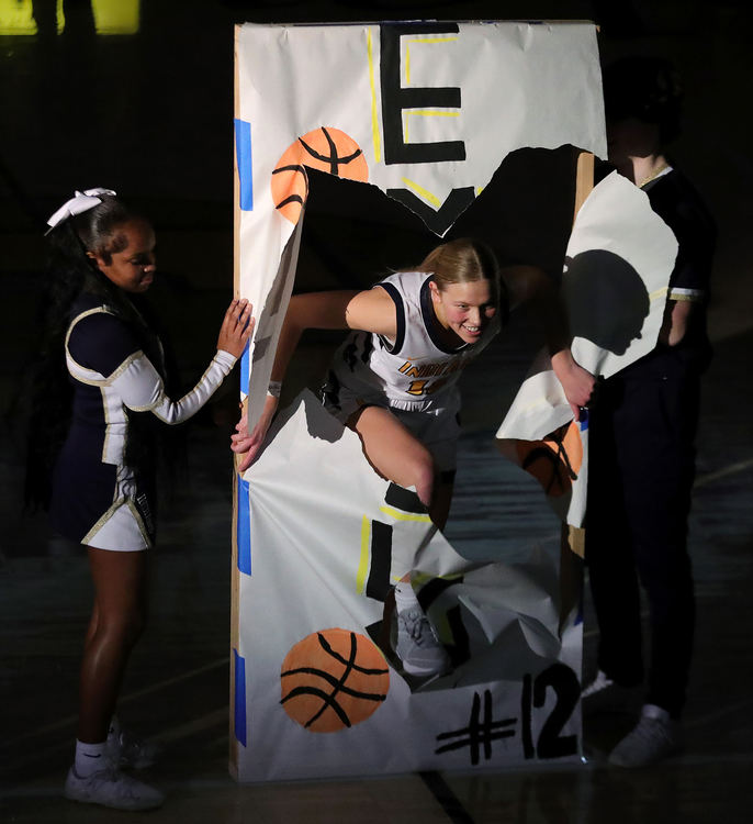 Sports Feature - 2nd place - Copley senior Emily Kerekes breaks through her banner during pregame announcement before a high school basketball game against Revere in Copley, Ohio. (Jeff Lange/Beacon Journal / Akron Beacon Journal)