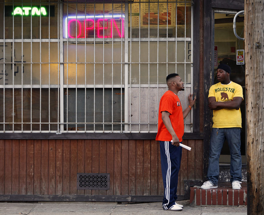 Story - 1st place - Safe Streets East outreach worker Corey Peterkin (left) talks to a client at the corner of N. Belnord Avenue and Orleans Street in Baltimore, MD. (Jonathan Quilter / The Columbus Dispatch)