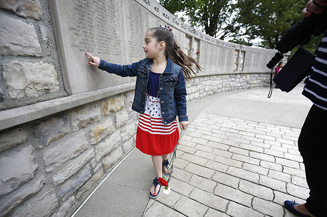 General News - 1st place - Olivia Gresko, 6, of Willoughby, finds her father's name on the wall following the Ohio Peace Officers' Memorial Ceremony at the Ohio Peace Officer Training Academy in London. Her father, Jason Gresko of the Willoughby Police Department, died in the line of duty on Sept. 21. 2012. (Jonathan Quilter / The Columbus Dispatch)