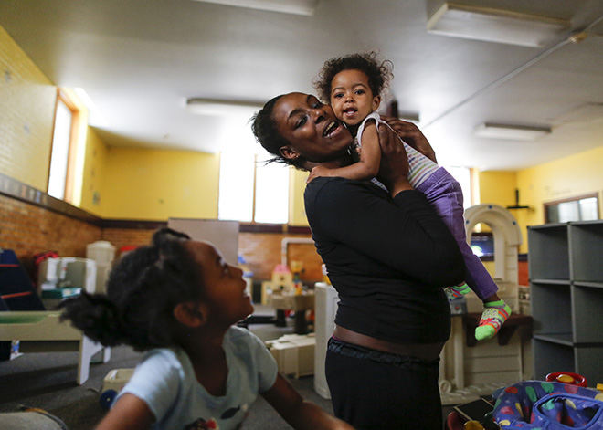 Portrait - 2nd place - Nicole Barnes snuggles her daughter Camille Cain, 18-months, while she plays with her other daughter Ta'Nyla Barnes, 5, at Family House. The non-profit will soon be providing day care for children of homeless families so people like Nicole can find work and get back on their feet.  (Andy Morrison / The (Toledo) Blade)