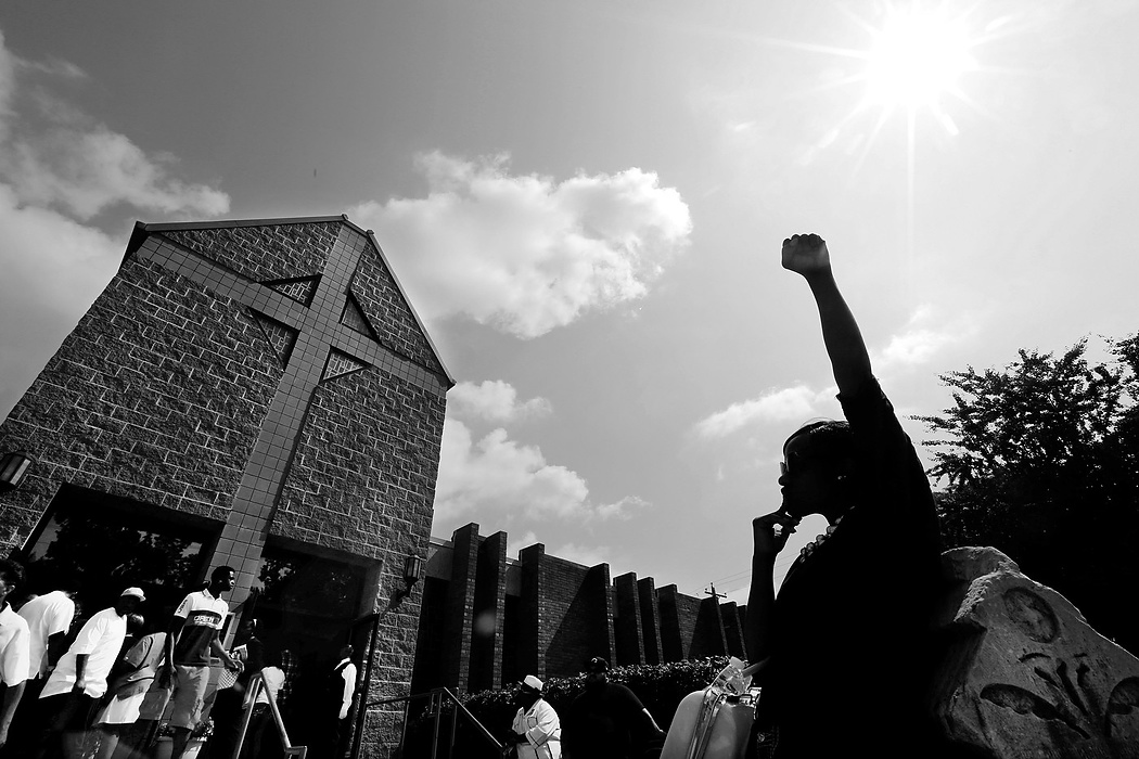 First Place, Photographer of the Year - Large Market - Carrie Cochran / Cincinnati EnquirerJeRee Wilson of Winton Hills, the cousin of one of Samuel DuBose's daughters, stands outside of the Church of the Living God in Avondale before Samuel DuBose's funeral.  DuBose was the unarmed Cincinnati man who was shot and killed by University of Cincinnati police officer Ray Tensing during a traffic stop on July 19 in Mount Auburn. 