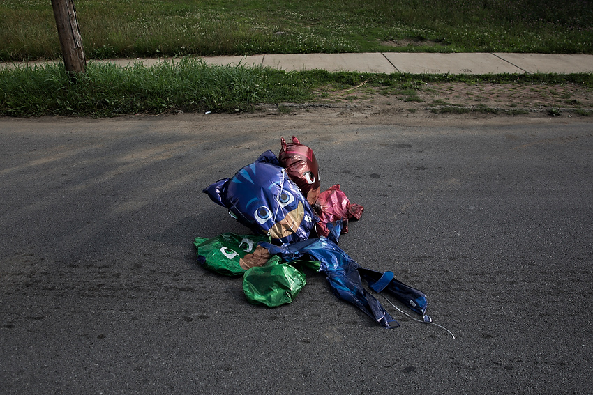 First Place, Feature Picture Story - Liz Moughon / Ohio UniversityOver a month after Dequante's funeral, deflated Paw Patrol balloons blow into the street after barely holding onto his front porch rail. These were his favorite cartoon characters.