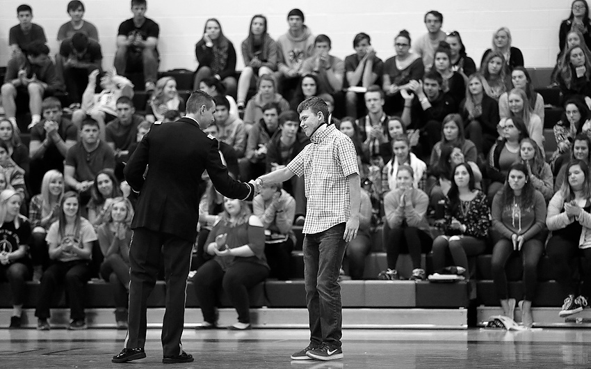 Second Place, Feature Picture Story - Jonathan Quilter / The Columbus DispatchLogan shakes hands with Army Capt. Evan M. Peck who was there to present Logan with an award of courage during an assembly at West Liberty-Salem High School less than two months after the shooting.