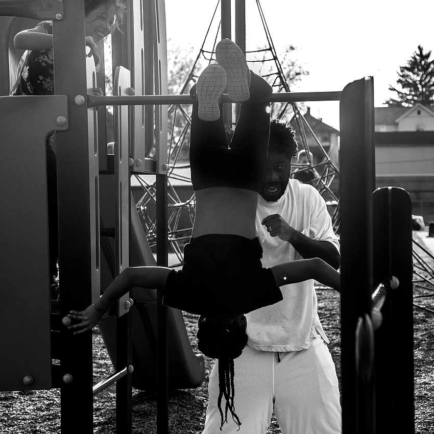 Third Place, Feature Picture Story - Jessica Phelps / Newark AdvocateDesmond Gordon pretends to uses his oldest daughter Cadiera, 10, as a punching bag, while the next oldest daughter, Keionna, 8, laughs and eggs him. Desmond often takes his children to the playground near his home in Newark, Ohio, because he believes in being active and actively participating in their lives.