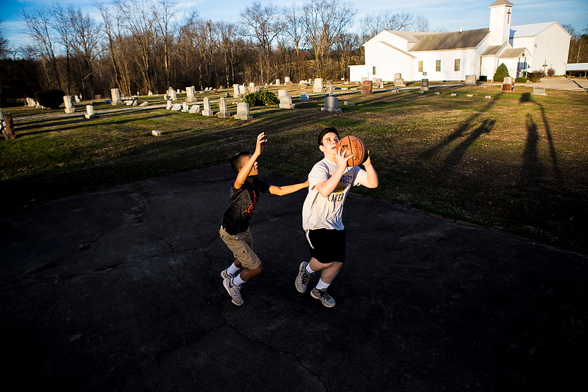 Award of Excellence, Feature Picture Story - Erin Clark / Ohio UniversityMason Phillips, left, and Alex Caldwell play a game of basketball outside of the Torch Baptist Church. The church is the original place of worship in Torch and is part of the reason why the town received its name. In the late 1800's, residents would carry torches with them to guide their way to church. What used to be a one room log cabin, the church has grown to be a community hub to about 40-50 members from different communities.