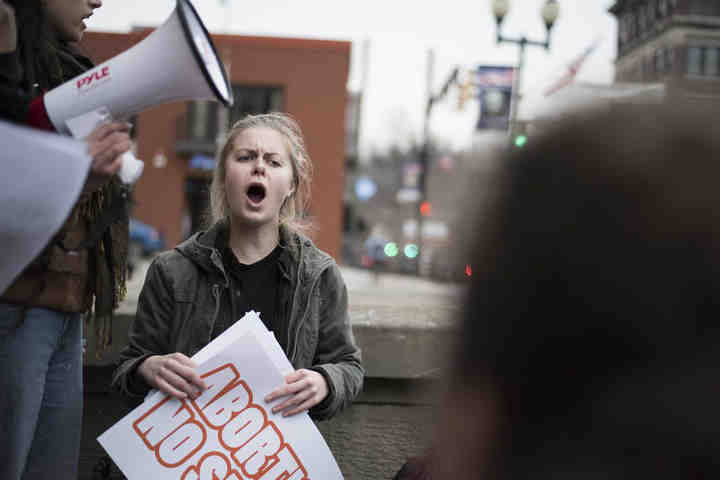 First place,  - Alexandria Skowronski / Ohio UniversityMegan Carter, of Longmont, Colorado, and president of the Intersectional Feminist Alliance at Ohio University, listens as fellow IFA members speak out during the IFA Positive Rally on Court Street in Athens.  (Alexandria Skowronski/Ohio University)