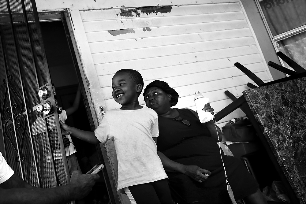 First Place, News Picture Story - Katie Rausch / The BladeJeremiah Slaughter, 5, left, plays on the front porch of his grandmother's house in East Cleveland. His grandmother Brenda Slaughter, right, said her family was moving out of their rental property after nine years because their landlord hadn't complied with ordered lead abatement. Their house was one of nearly 90 in Cuyahoga County for whom the Board of Health has issued Orders of Eviction after noncompliance with lead abatement. The process triggered once a child staying at the residence tests positive for elevated lead levels.