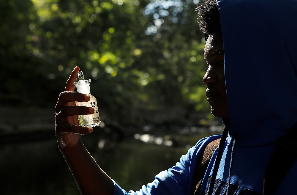 Second Place, News Picture Story - Andy Morrison / The BladeScott High School junior Juzarien Shoulders takes a water sample from Swan Creek at Highland Park in South Toledo.  The students were looking for for the presence of phosphorus, E. coli, pH balance, turbidity, and more.   