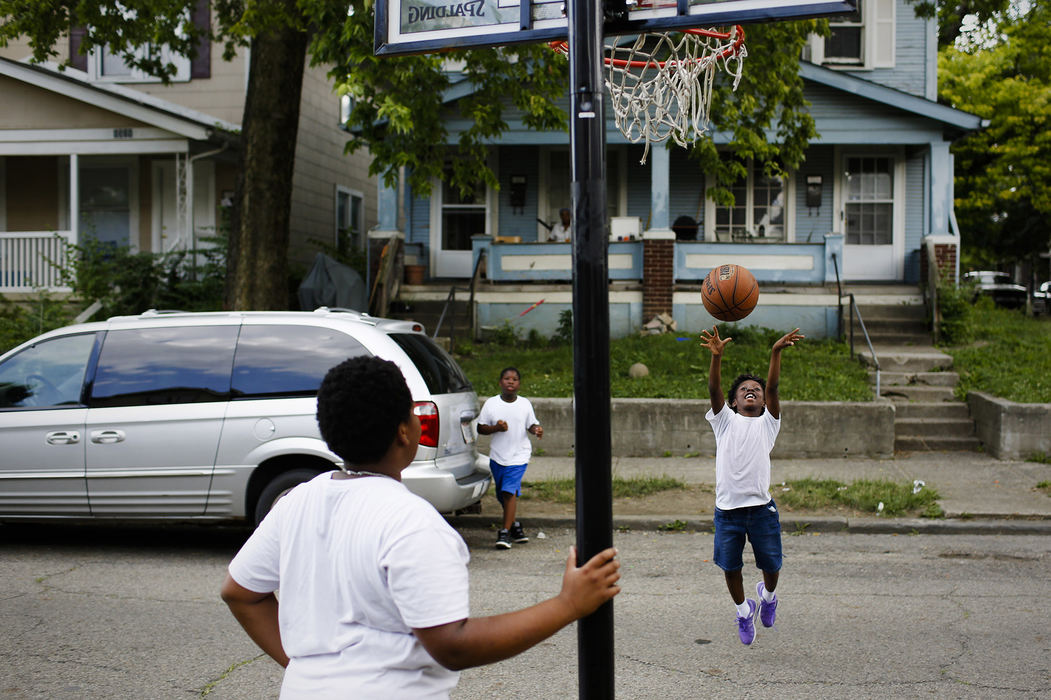 Jameliah Johnson, 8, right, shoots plays a game of basketball with her brothers Donivieon Greendiles, 14, left, and Jerome Johnson, 9, center, outside their home on Fifth Street and Seventh Avenue in the Weinland Park neighborhood on Wednesday, June 21, 2017 in Columbus, Ohio.