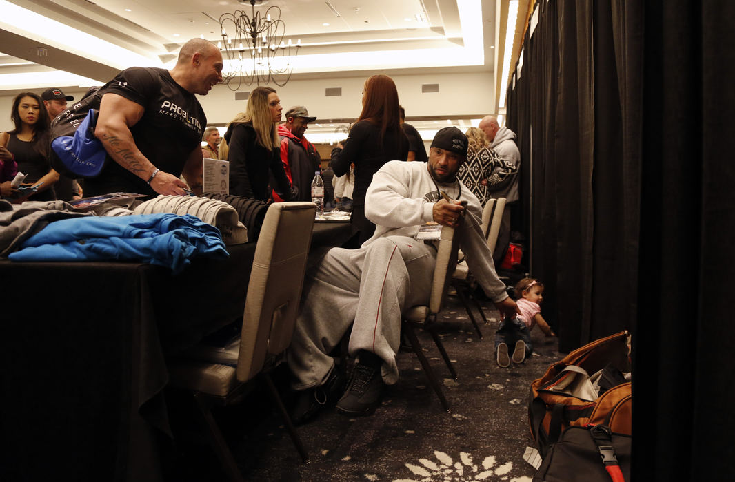 Arnold Classic competitor Juan Morel stops to get his daughter Izabella while signing a picture for a fan during a meet and greet at the Hilton Hotel in Columbus, Ohio on March 2, 2017.  Juan has become fan favorite over the past couple of years.  