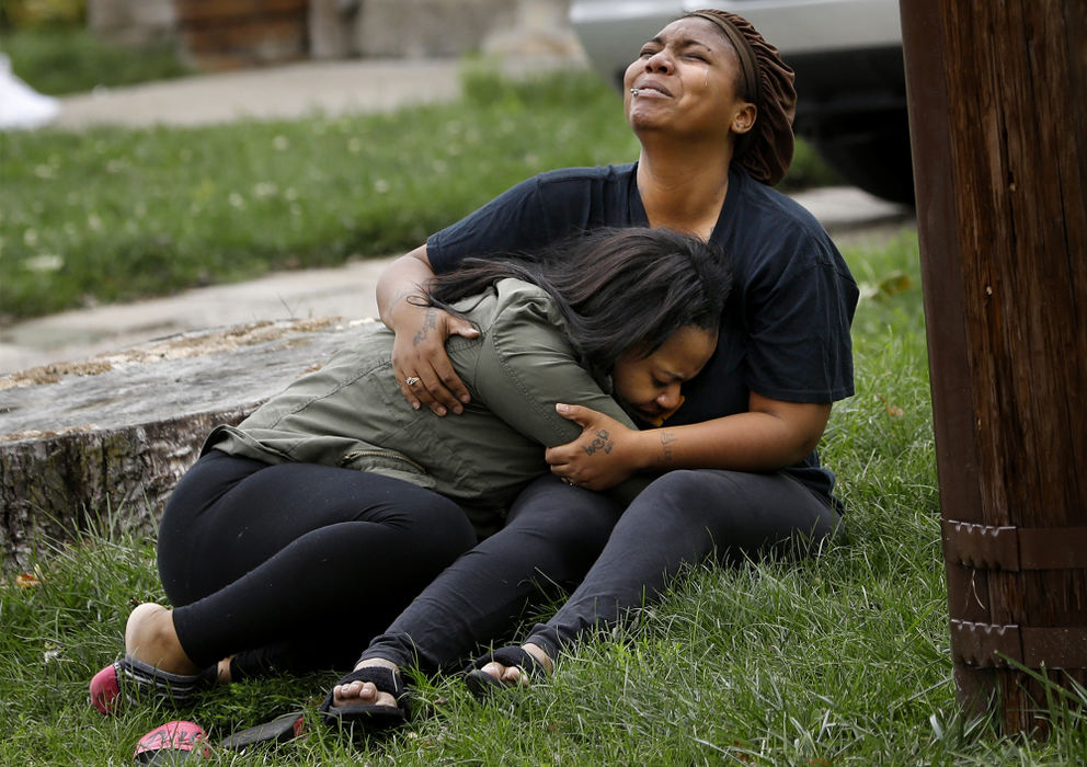 "That's my baby," a woman sobs, left, as another woman cries out, "That's my brother," while holding one another in the front yard as Toledo police investigate a shooting Tuesday, October 10, 2017, at 729 Brighton Ave. in South Toledo. Toledo police spokesman Sgt. Kevan Toney said an 18-year-old man and 18-year-old woman had been pronounced dead after the shooting. Police later identified the victims as Gregory Stone and Deiyana Porter, who were shot while in a car parked behind the house.