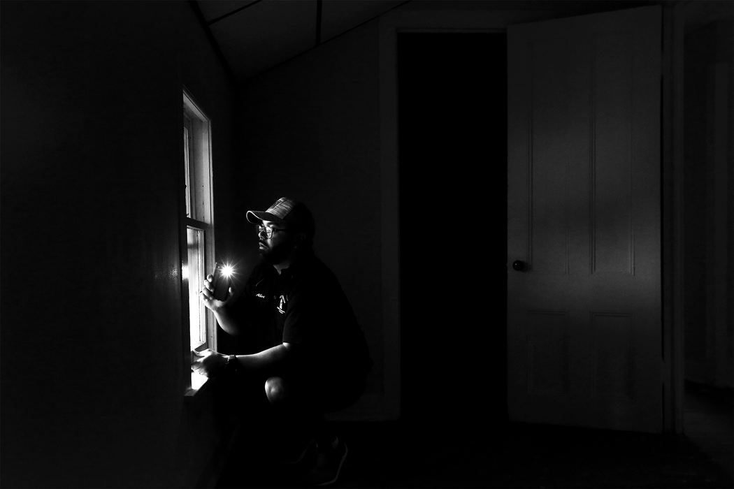 Albert Algerian, a Rochester Code Enforcement Officer, uses his phone light to check for flaking paint on a window during an inspection demonstration Thursday, June 22, 2017, at a rental home in Rochester, New York. A new Toledo law, based on Rochester's decade-old lead law, requires rental buildings built before 1978 with up to four units and day-care centers to be certified “lead-safe.”