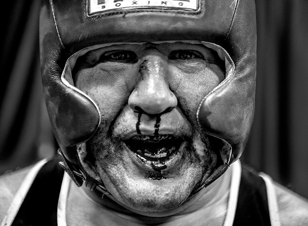First Place, George S. Smallsreed Photographer of the Year  - Jessica Phelps / Jessica PhelpsAaron Herron of the Franklin County Police Department, poses for a photo after losing his boxing match against Columbus firefighter, Dan Whalen, but proud of the the blood running from his nose and mouth. Herron, who had never boxed before, said he was happy to contribute to a good cause. 