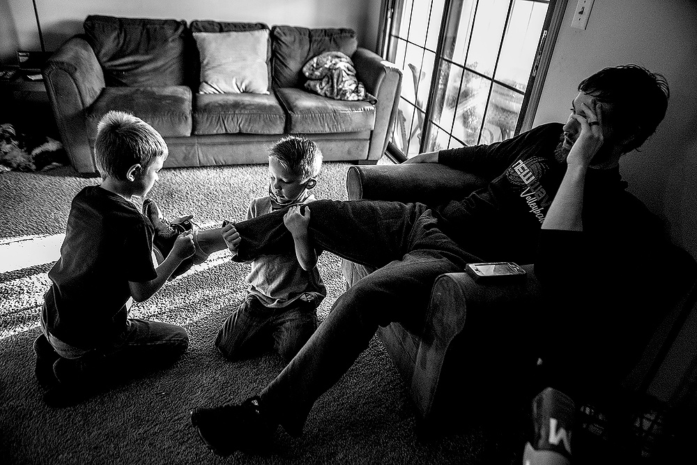 First Place, George S. Smallsreed Photographer of the Year  - Jessica Phelps / Newark AdvocateArcher and Beau put shoes on their new adoptive dad, Brett, before they leave for school. Brett and his wife Caity have loved being new parents, but are having trouble keeping up with the high energy levels of all four children. 