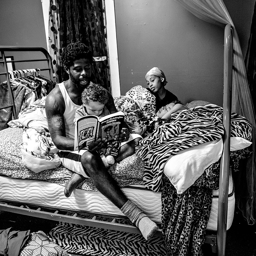 First Place, George S. Smallsreed Photographer of the Year  - Jessica Phelps / Newark Advocate Desmond Gordon, a 35-year-old union electrician, is the father of four children: three girls and one boy. When asked what fatherhood means to him, Desmond responded “Fatherhood definitely means responsibility, guidance, protection, counsel. It’s scary. It’s emotional. I have a lot of fun as a dad. I look at the world differently now because kids teach you things that adults won’t.”Having two girls in elementary school has taught him a lot about having patience for fashion shows and makeup lessons, but most importantly, “Having daughters, the thing I have learned the most is how to be a gentleman. To make sure the way I treat my wife and the way I treat my daughters is the way they expect men to treat them, and nothing less.”Desmond loves watching his children excel, and grow whether it’s in sports or school, or in the way they learn to treat others. He is determined to make sure they have dreams and help them follow those dreams.Each night before tucking his daughters into bed, Desmond reads part of a chapter book to them, usually with his son, 'Lil Des', crawling over him wanting his attention too. The night of April 12 2017 in Newark, Ohio, was no different. 