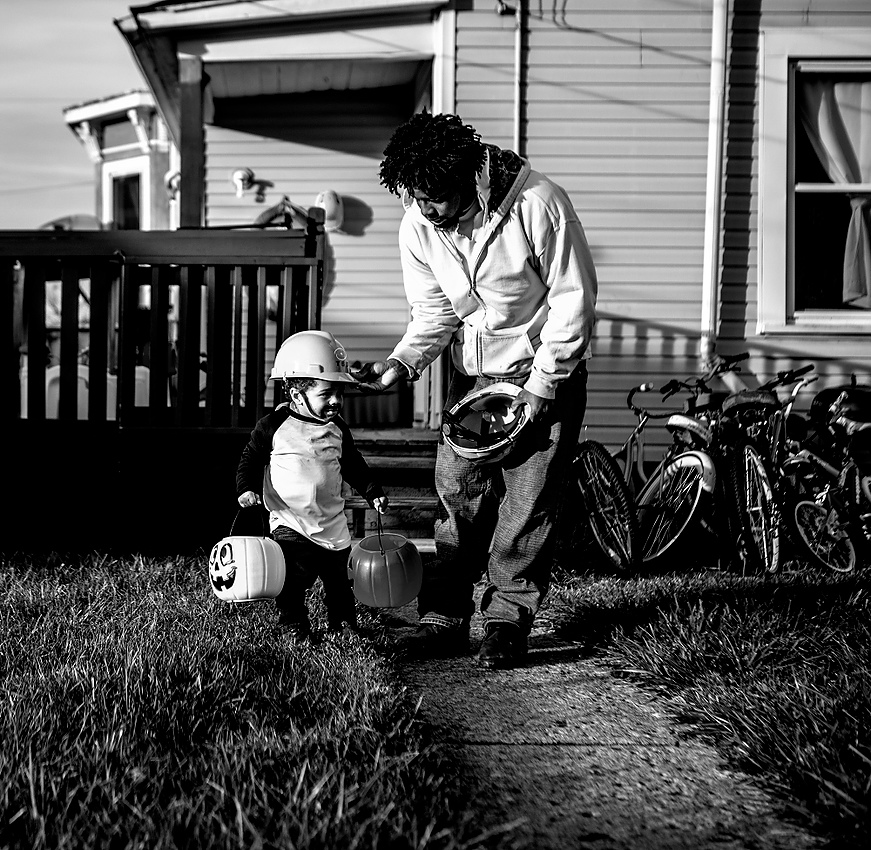 First Place, George S. Smallsreed Photographer of the Year  - Jessica Phelps / Jessica PhelpsDesmond Gordon helps his son, 'Lil' Des with his Halloween costume. Both father and son went trick-or-treating as electricians. 'Lil" Des's costume was complete with a beard his mom drew on him to complete the look. 