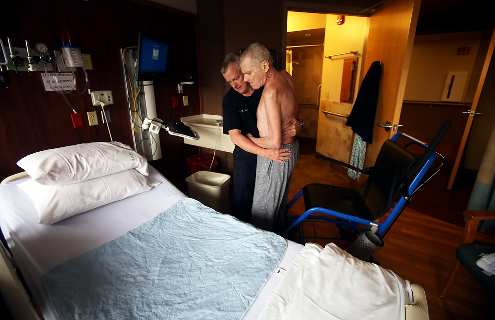 Second Place, George S. Smallsreed Photographer of the Year  - Lorrie Cecil / ThisWeek Community NewsAndy helps his brother Mark back into bed after going to the bathroom.  Early into his diagnoses Mark only wanted Andy to help him with personal things such as this.