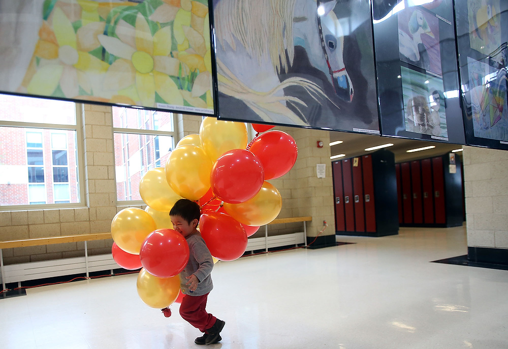 Second Place, George S. Smallsreed Photographer of the Year  - Lorrie Cecil / ThisWeek Community NewsNiall Zhao, 3, of Upper Arlington laughs as he runs through the halls of Westerville Central High School with balloons during the Ohio Chinese Festival on Saturday February 4.    Photo by Lorrie Cecil/ ThisWeek Newspapers 