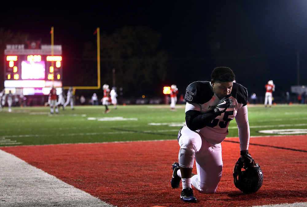 Second Place, George S. Smallsreed Photographer of the Year  - Lorrie Cecil / Lorrie Cecil/ThisWeekPickerington North's Jalen Bankston kneels for a moment of prayer prior to the start of their first round playoff game at Wayne High School on Friday November 3.  Pickerington won 41-20.  