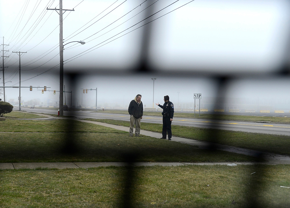 Third Place, George S. Smallsreed Photographer of the Year  - Erin McLaughlin / Sandusky RegisterSandusky police Sgt. Tracey Susana talks with a man after being called to a residence on March 21, 2017. Susana is a Sandusky native who counts more than 20 years on the job. She figures she can make her way to essentially any address in the city without hesitation.