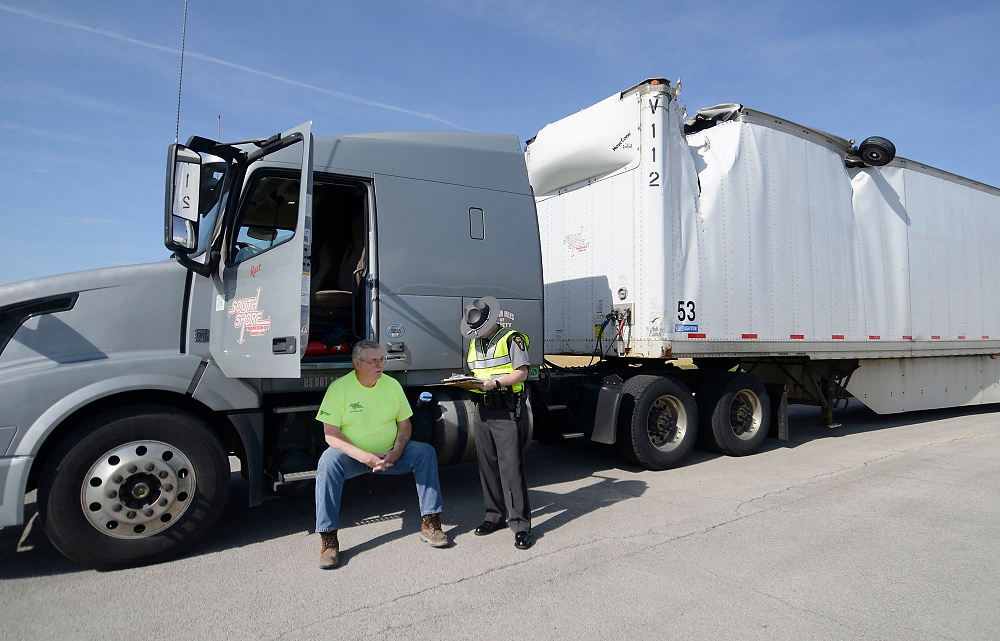 Third Place, George S. Smallsreed Photographer of the Year  - Erin McLaughlin / Sandusky RegisterA state trooper talks to the driver of a semitrailer who was driving down Ohio 53 when the trailer was clipped by an airplane landing at the Fremont Airport in Ballville Township on May, 9, 2017. "I was just driving down Ohio 53, and I heard a boom,” said the driver. “It rocked the trailer. I thought the semi was going over.” The airplane left one of its tires behind when it clipped the top of the trailer. No one was injured.