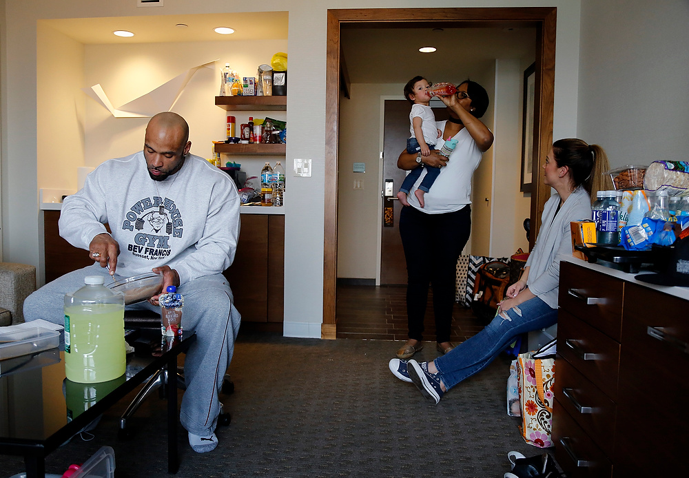 , Ron Kuntz Sports Photographer of the Year - Kyle Robertson / Columbus DispatchJuan Morel eats a meal in his hotel room while is mother, Manuela, watches his daughter Izabella and wife, Karen, looks on in his hotel room in Columbus, Ohio on March 2, 2017.  Juan is one of the only classic competitors that brings his family with him for a show.  