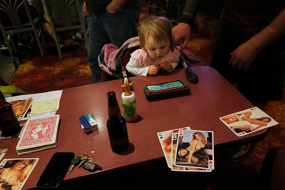 Second Place, Ron Kuntz Sports Photographer of the Year - Katie Rausch / The Blade/Katie RauschAs the only child present, Rose, 2, watches cartoons while her father bowls with other members of the Kenny Mummert Memorial League at Twin Oakes Lanes in North Toledo. The league awards cash prizes for strikes and spares; the all-male teams keep track with playing cards. Rose's mother is tends bar at the alley. 