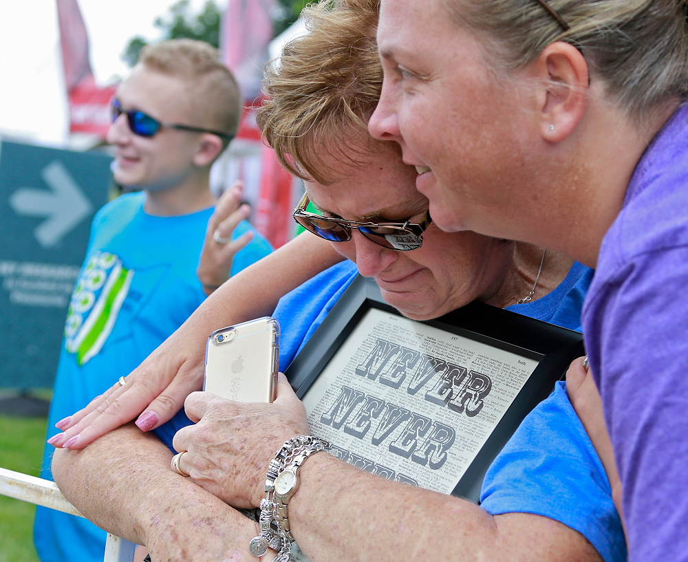 Third Place, Ron Kuntz Sports Photographer of the Year - Barbara J. Perenic / The Columbus DispatchHolding a sign that says, "Never, Never, Never Forget," Teresa Bentley of Hilliard, left, is comforted by Cheryl Harris of Hilliard, right, for Bentley's husband, Tommy, who passed away in June, at the 180-mile Pelotonia finish line at Kenyon College in Gambier .