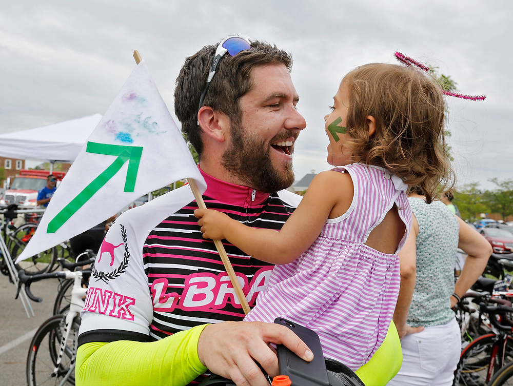 Third Place, Ron Kuntz Sports Photographer of the Year - Barbara J. Perenic / The Columbus DispatchL Brands rider Jeff Polesovsky of Upper Arlington holds his 2-year-old daughter Ella after arriving at the Pelotonia finish line in New Albany. This was Jeff's third year riding and his second as a high roller fundraiser. 