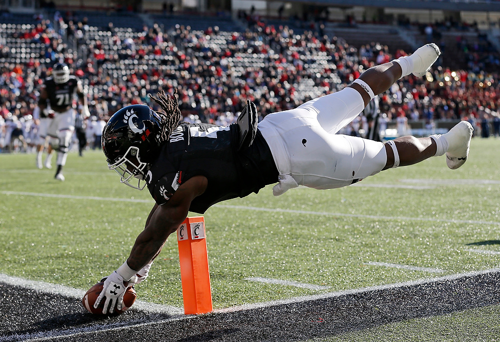 Award of Excellence, Ron Kuntz Sports Photographer of the Year - Sam Greene / The Cincinnati EnquirerCincinnati Bearcats running back Mike Boone (5) leaps and stretches to put the ball across the goal line for a game-tying 2-point conversion in the fourth quarter of the NCAA football game between the Cincinnati Bearcats and the Connecticut Huskies at Nippert Stadium in Cincinnati on Saturday, Nov. 25, 2017. The Bearcats took a 22-21 win on senior day after the Huskies missed an extra point attempt with no time left on the clock.