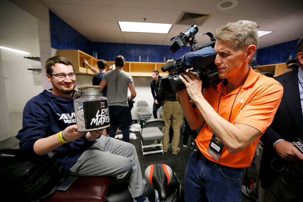 Award of Excellence, Ron Kuntz Sports Photographer of the Year - Sam Greene / The Cincinnati EnquirerStudent manager Alex Poedtke shows off the team's "urn" holding the ashes of the team's February calendar in the locker room a practice session ahead of the NCAA Tournament Sweet 16 matchup between the Xavier Musketeers and the Arizona Wildcats at the SAP Center in San Jose, Calif., on Wednesday, March 22, 2017.