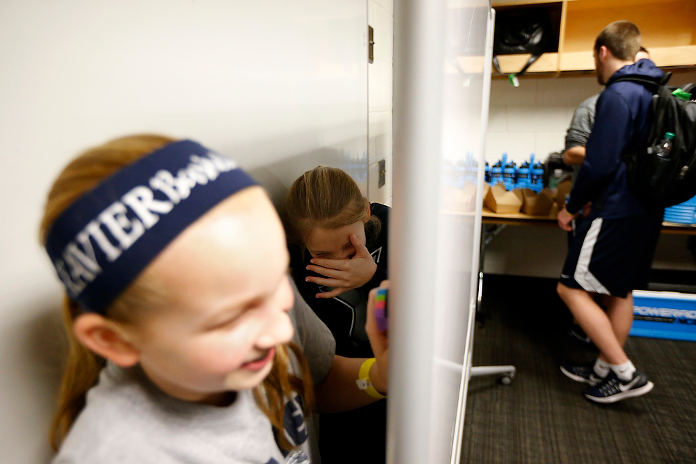 Award of Excellence, Ron Kuntz Sports Photographer of the Year - Sam Greene / The Cincinnati EnquirerHead coach Chris Mack's daughters Lainee and Hailee hide behind a whiteboard as media fills the locker room after a practice session ahead of the Sweet 16 matchup.