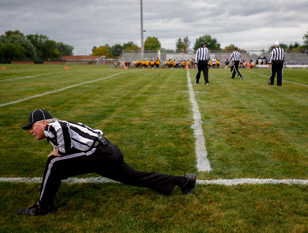Third Place, Chuck Scott Student Photographer of the Year - Emma Howells / Ohio UniversityA referee stretches before a high school football game between the Marion-Franklin Red Devils and Beechcroft Cougars on Friday, September 1, 2017 in Columbus, Ohio.