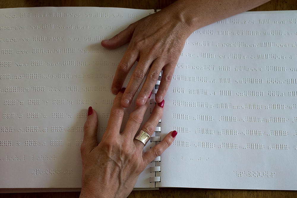 Third Place, Chuck Scott Student Photographer of the Year - Emma Howells / Ohio UniversityJeri guides client Mary "Sunshine" Edwards' fingers over Sunshine's Braille workbook during one of their weekly lessons. Jeri fears that without daily practice, Sunshine will be slow to pick up the new language.