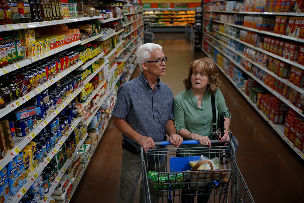 Third Place, Chuck Scott Student Photographer of the Year - Emma Howells / Ohio UniversityRoger, one of Jeri's regular support service providers (SSP) looks for a particular pack of cookies while shopping for groceries in Walmart with Jeri. The role of an SSP is to assist the deaf-blind person with visual cues they are unable to see but not to rob them of their independence.