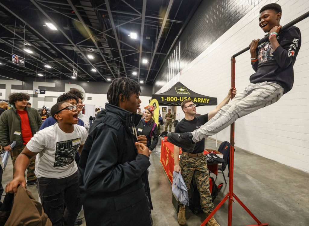 November - General News - 1st place - Ta’Ron Williams, an eighth grader at Sherman Elementary School, does pulls ups at the Marines exhibit during Toledo Public Schools’ annual Career Connect Expo at the Glass City Center in Toledo.  (Jeremy Wadsworth / The Blade)