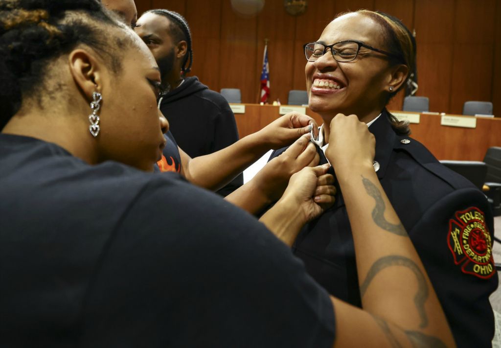 September - General News - 1st place - Komako Goolsby, the first African-American woman to be promoted to the Rank of Captain in the Toledo Fire Department, is pinned by family members at One Government Center in Toledo.   (Jeremy Wadsworth / The Blade)