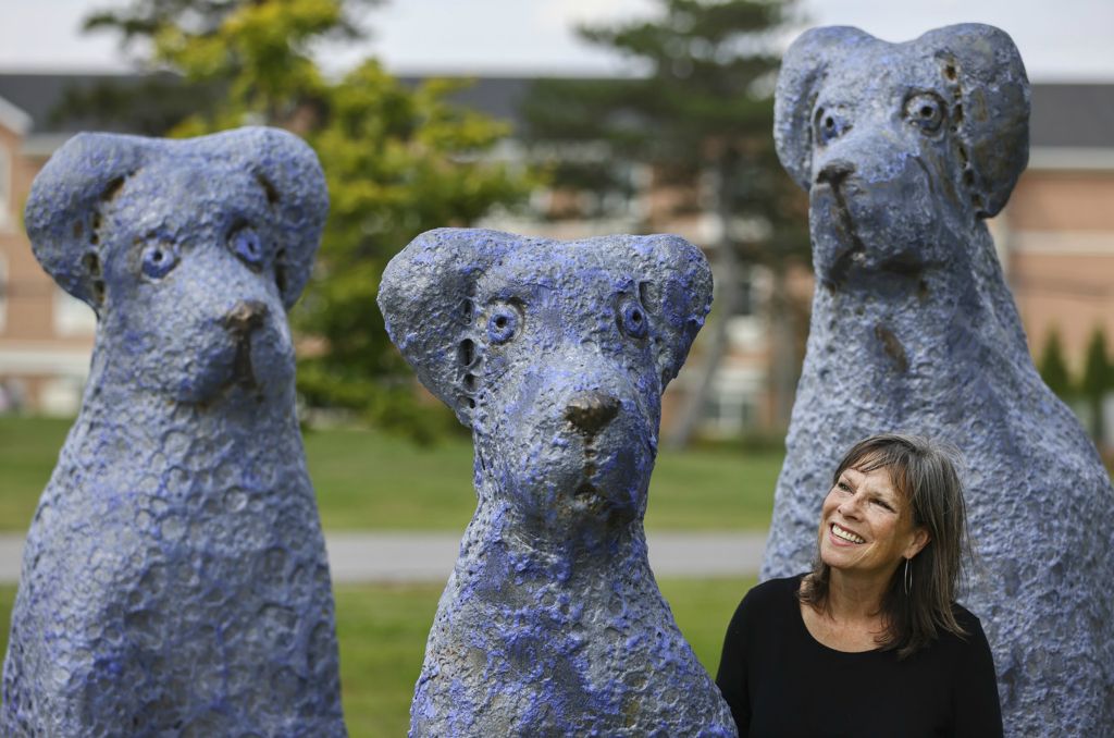 September - Portrait - 2nd place - Robin Ballmer, director of Main Art-ery which curates the exhibition, stands next to “Blue Dogs”, a sculpture by Mark Chatterley at Woodlands Park in Perrysburg.  (Jeremy Wadsworth / The Blade)
