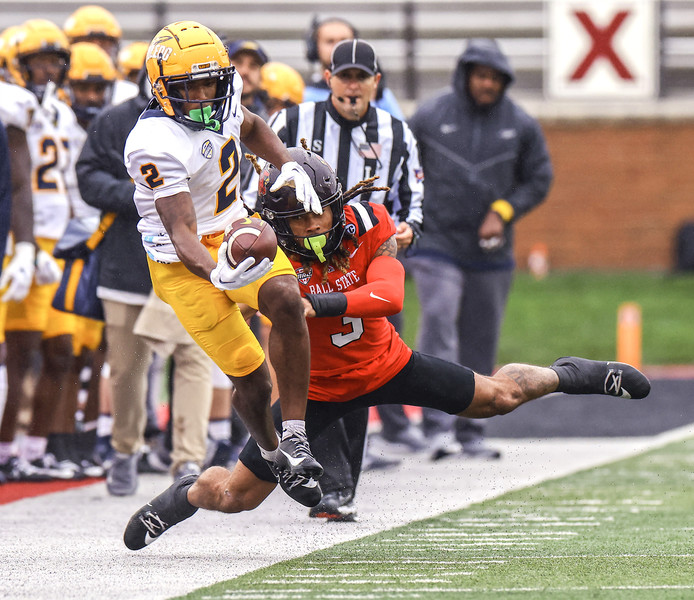 October - Sports - HM - University of Toledo wide receiver Junior Vandeross III stretches for extra yardage against  Ball State safety Jordan Riley at Scheumann Stadium in Muncie, Indiana.  (Jeremy Wadsworth / The Blade)