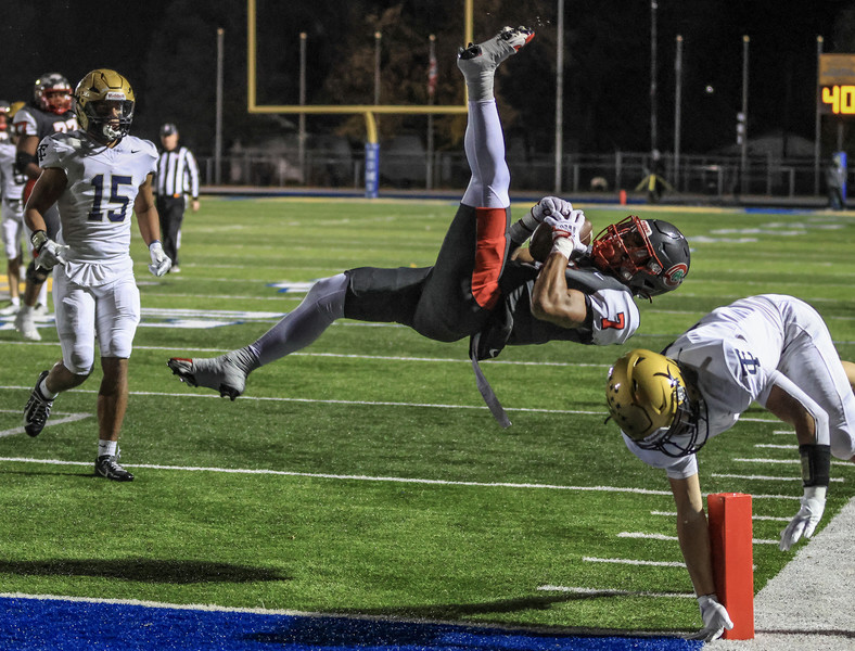 November - Sports - HM - Central Catholic running back Tyler Morgan goes airborne for extra yardage against  Tiffin Columbian defensive back A.J. Hickman during a Division III regional final playoff game at Robert J. Bishop Jr. Stadium in Clyde.   (Jeremy Wadsworth / The Blade)