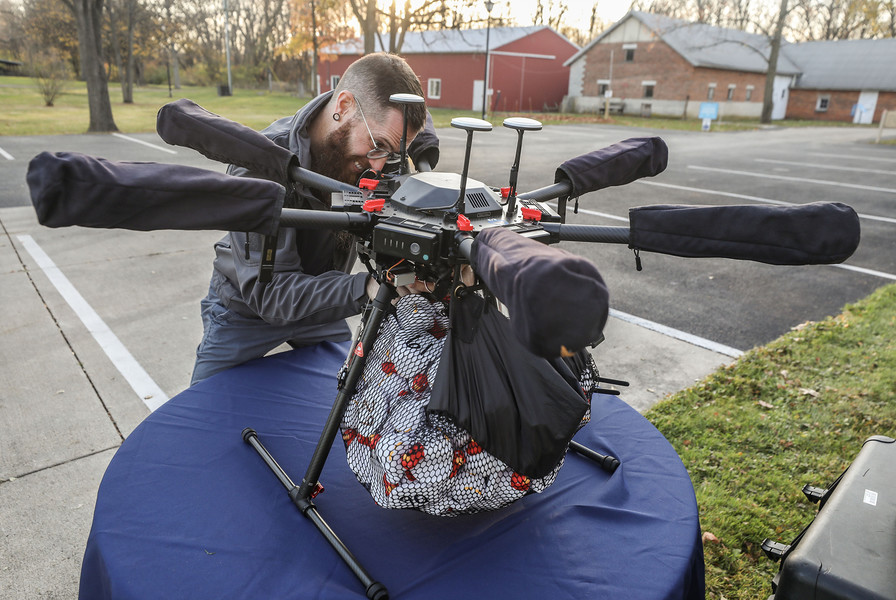 November - Story - 2nd place - Chris Aldrich of Toledo Aerial Media  loads 150 rubber turkeys on to a drone for the Turkey Drop Fundraiser at the Wood County Museum in Bowling Green.  The museum partnered with Toledo Aerial Media for a fun fundraising event in which participants could purchase a foam turkey for $50 each. A drone dropped 150 numbered foam turkeys in the lot. The three foam turkeys closest to the target won prizes.  (Jeremy Wadsworth / The Blade)