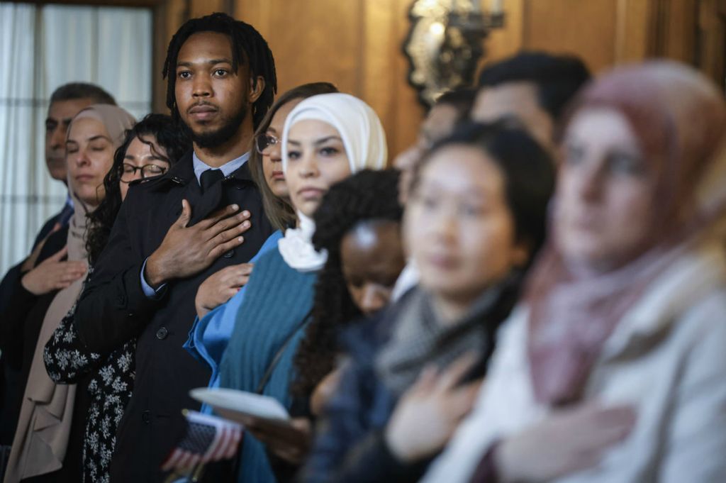  General News - 3rd place - Kizito Akunna recites the Pledge of Allegiance during a naturalization ceremony at the Toledo Club in Toledo.   (Jeremy Wadsworth / The Blade)}