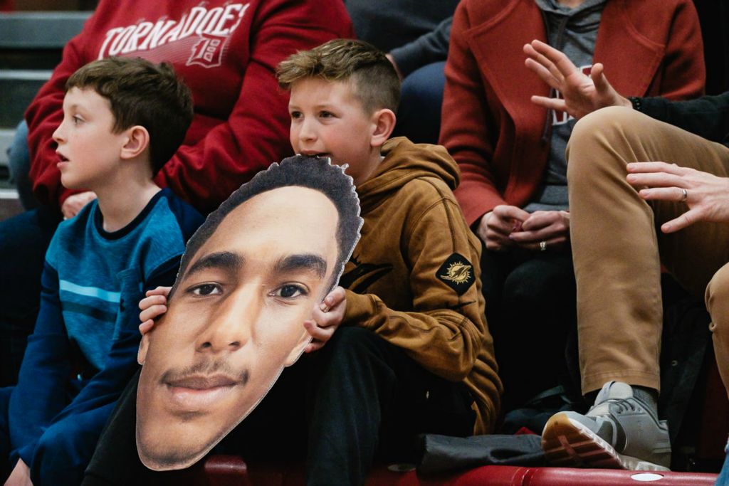  Sports Feature - 2nd place - A young Dover boys' varsity basketball fan gnaws on the giant cutout of Trey Ridgeway during a game against Tusky Valley, in Zoarville. (Andrew Dolph / The Times Reporter)}