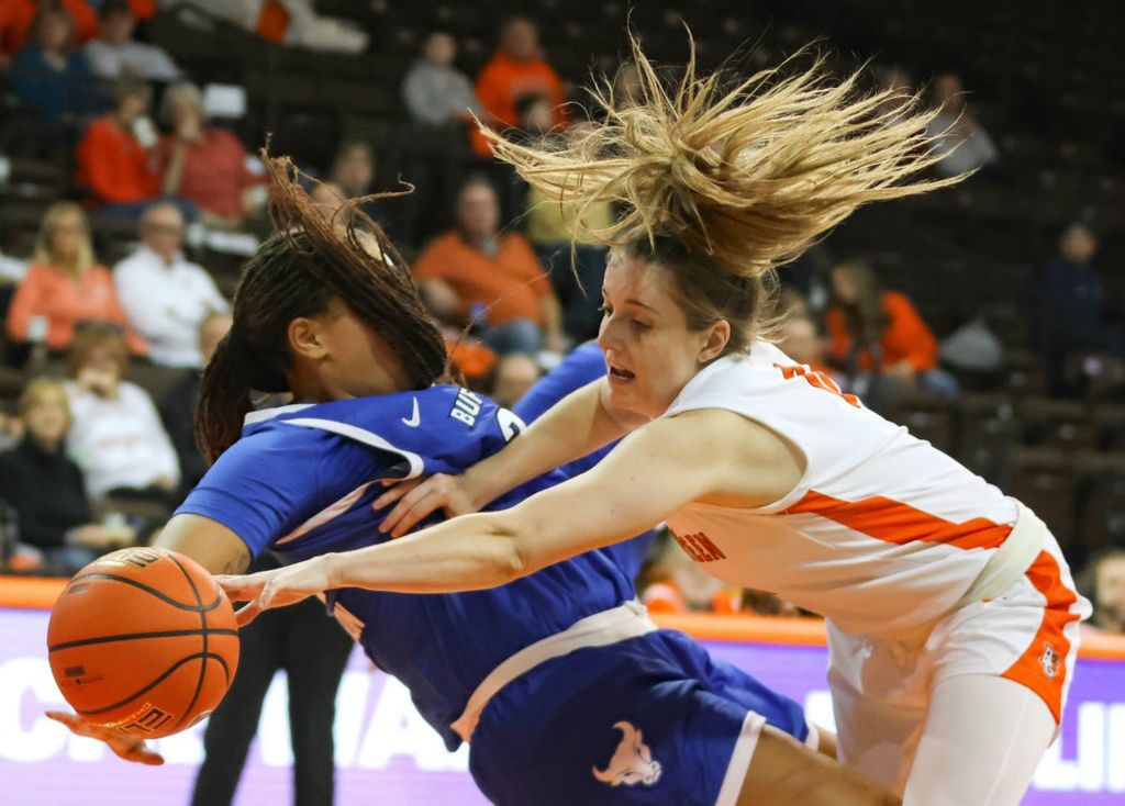  Sports - 1st place - Buffalo’s Kiara Johnson (left) takes a charge by Bowling Green’s Morgan Sharps during a Mid-American Conference game at BGSU’s Stroh Center in Bowling Green, Ohio. (Kurt Steiss / The Blade)}
