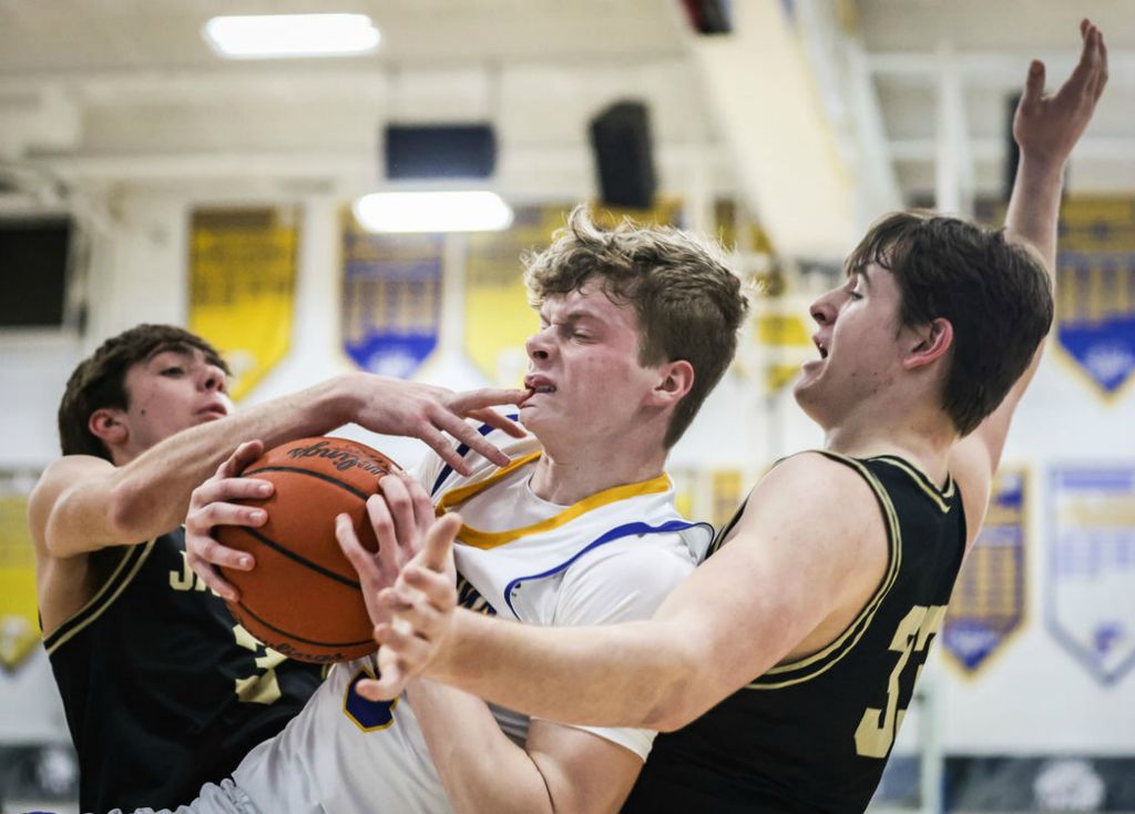 Sports - 3rd place - Findlay’s Ben Best (center) drives to the basket against  Perrysburg’s Carter Young (left) and Matt Hubbard during a game in Findlay.   (Jeremy Wadsworth / The Blade)}