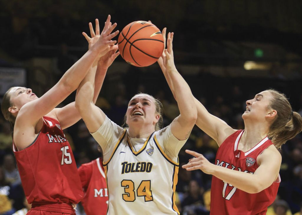  Sports - HM - Toledo’s Jessica Cook and Miami’s Amber Tretter (left) and Nuria Jurjo reach for a rebound during a MAC basketball game at the University of Toledo’s Savage Arena. (Rebecca Benson / The Blade)}